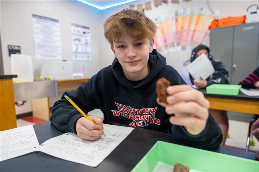 Students study rocks in a science lab